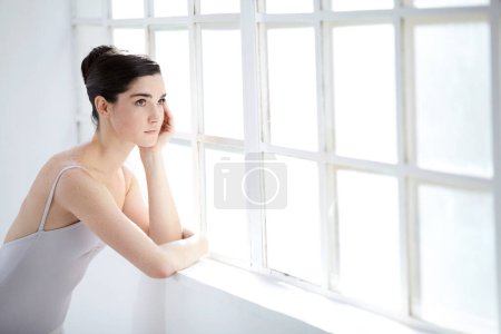 Photo for Woman, ballet dancer and thinking at window for future creative, artistic vision or passion goals. Female person, elegant costume and idea thoughts for hair bun dreaming, career or performance plan. - Royalty Free Image