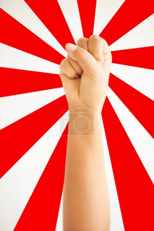 Photo for Hand in air, fist up in protest in studio isolated on a red and white background for freedom, human rights and justice, equality and sign. Arm, closeup and fight for revolution, power and violence - Royalty Free Image