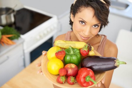 Photo for Portrait, health and vegetables with a woman in the kitchen of her home for nutrition, diet or meal preparation. Face, ingredients and a recipe for cooking food with a young person in her apartment. - Royalty Free Image