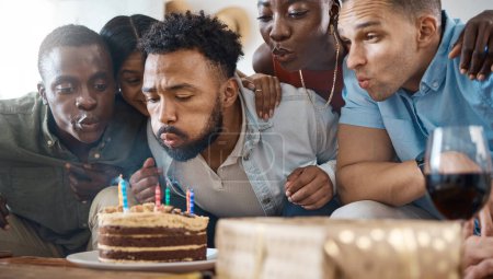 Téléchargez les photos : Il a besoin d'aide. un jeune homme souffle ses bougies d'anniversaire à sa fête à la maison - en image libre de droit