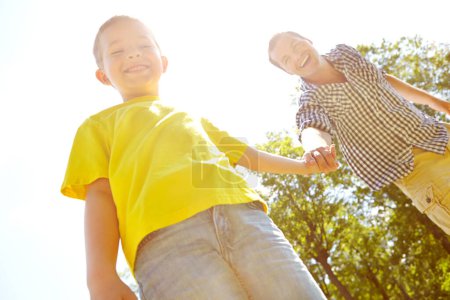 Foto de Momentos especiales padre-hijo. El joven padre y su hijo pasan tiempo al aire libre mientras sonríen ampliamente - Imagen libre de derechos