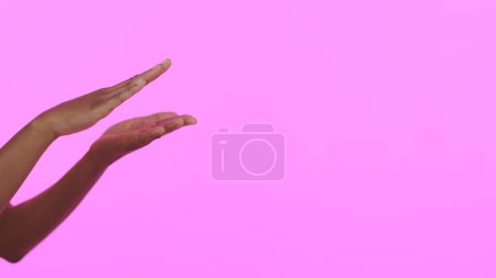 Téléchargez les photos : Mains, soins de la peau et maquettes avec une personne sur fond rose en studio pour la publicité ou le marketing. Beauté, bannière et espace avec un modèle en gros plan sur un mur de couleur pour un succès salon ou spa. - en image libre de droit