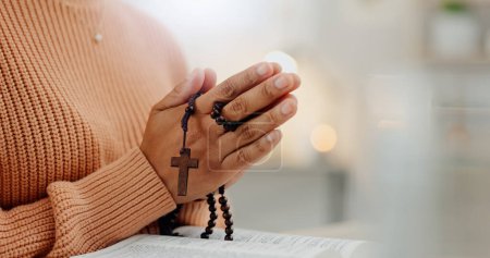 Photo for Closeup hands, rosary and a bible for prayer, spiritual support and hope from Jesus. House, God and a person with a cross and book for help, trust and gratitude as a Christian for the gospel. - Royalty Free Image
