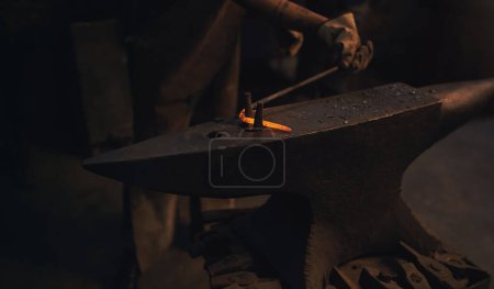 Foto de Lo que está doblado puede ser igual de hermoso. un herrero que trabaja con una varilla de metal caliente en una fundición - Imagen libre de derechos