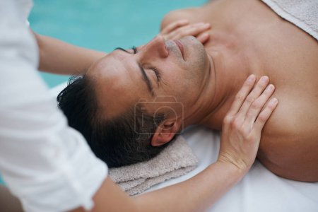 Téléchargez les photos : Éliminer le stress d'une longue semaine. un bel homme profitant d'un massage au spa - en image libre de droit