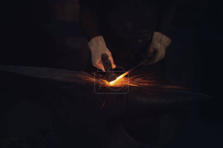 Foto de Puede ser de acero, pero vale más que el oro. un herrero golpeando una barra de metal caliente con un martillo en una fundición - Imagen libre de derechos