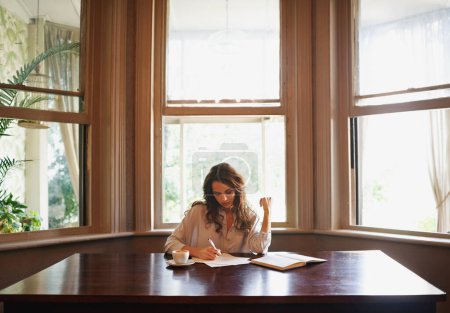 Foto de Ella siempre escribe. una joven atractiva escribiendo en un ambiente relajado en casa - Imagen libre de derechos