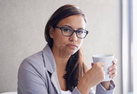 Foto de Tomando un muy necesario descanso para tomar café. Retrato de una atractiva joven empresaria tomando café en su oficina - Imagen libre de derechos