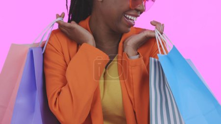 Foto de Mujer, feliz con bolsa de compras y venta al por menor, comercio y moda, venta o tienda de descuento en fondo rosa. Cliente con compra, mercado y lujo con servicio, entusiasmado con los ahorros en estudio. - Imagen libre de derechos