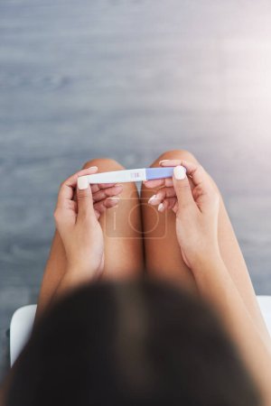 Foto de Are you ready for motherhood. an unrecognizable woman taking a pregnancy test at home - Imagen libre de derechos