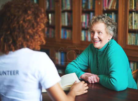 Photo for Smiles are the only reward one needs. a volunteer reading to a senior woman at a retirement home - Royalty Free Image