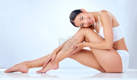Photo for Good things come to those with good skincare. Studio shot of a beautiful young woman sitting in her underwear and posing against a grey background - Royalty Free Image