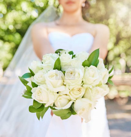 Téléchargez les photos : Gros plan de la mariée tenant un bouquet de fleurs debout à l'extérieur par une journée ensoleillée. Beau bouquet de mariage de roses blanches. - en image libre de droit
