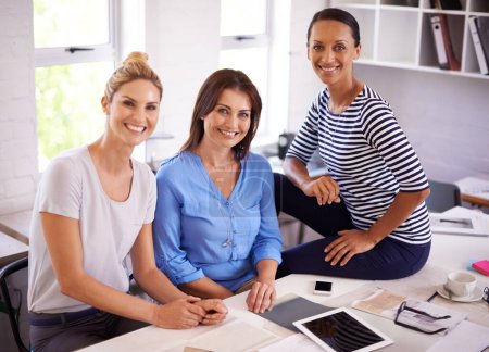 Photo for Making a success of their start-up business. Three confident young businesswomen smiling at the camera - Royalty Free Image