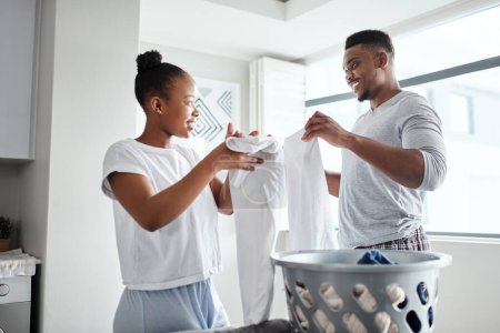 Photo for The load is smaller when we do it together. a happy young couple doing laundry together at home - Royalty Free Image