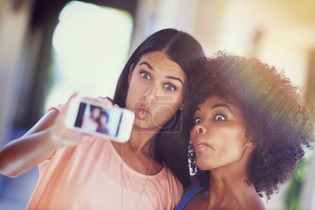 Foto de Recuerdos locos que vale la pena recordar. dos novias tomando una selfie en un teléfono móvil - Imagen libre de derechos