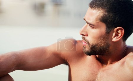 Foto de Tomando un respiro muy necesario. un joven deportista guapo sin camisa sentado mientras toma un descanso después de un entrenamiento al aire libre - Imagen libre de derechos