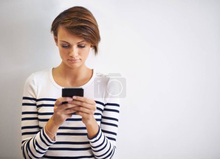 Foto de Perdido en la conversación móvil. Una foto recortada de una hermosa joven usando un teléfono inteligente - Imagen libre de derechos
