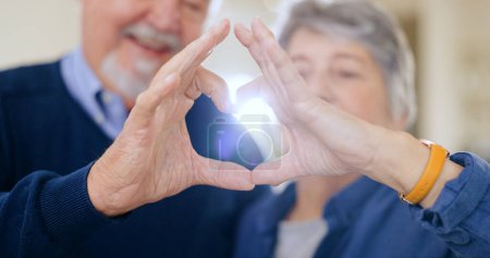 Photo for Heart, hands and senior couple with love, trust and hope in their home bonding, relax and free. Gratitude, care and old people with thank you, finger or emoji frame for kindness, security or support. - Royalty Free Image
