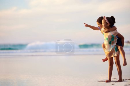 Téléchargez les photos : Allumez-moi avec votre jeunesse. un frère et une sœur adorables collant à la plage - en image libre de droit