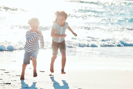 Foto de Es hora de algunas vibraciones de playa. una adorable niña y niño divirtiéndose en la playa - Imagen libre de derechos