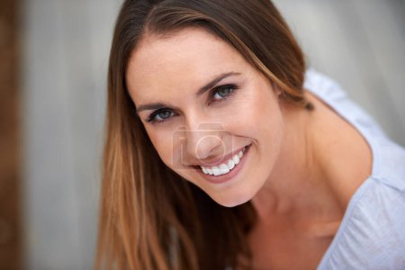 Photo for Smiling is the prettiest accesory you can wear. Portait of a young woman sitting outdoors - Royalty Free Image