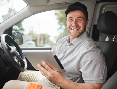Photo for Just double checking my route. Cropped portrait of a handsome young delivery man using a tablet while sitting in his van - Royalty Free Image