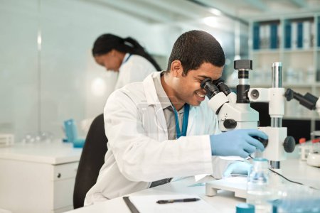 Foto de Puedo sentir que se avecina un nuevo avance. un joven científico usando un microscopio en un laboratorio - Imagen libre de derechos