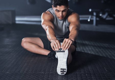Téléchargez les photos : Il se prépare à travailler ses muscles. un jeune homme musclé faisant de l'exercice dans une salle de gym - en image libre de droit