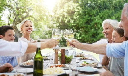 Téléchargez les photos : Quand la famille se réunit, elle appelle à une célébration. une famille partageant un toast tout en profitant d'un repas ensemble - en image libre de droit