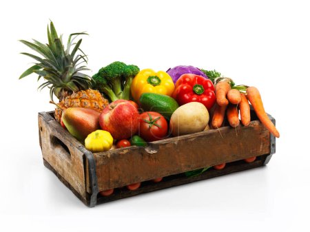 Foto de Sobreabundan las naturalezas. Estudio de una caja llena de verduras frescas y frutas sobre un fondo blanco - Imagen libre de derechos