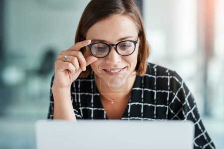 Foto de Los números están empezando a verse bien. una joven mujer de negocios feliz trabajando en un ordenador portátil en una oficina - Imagen libre de derechos