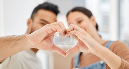 Photo for I cant wait to raise a family with you in this loving home. Closeup shot of a couple making a heart shape with their hands while moving house - Royalty Free Image
