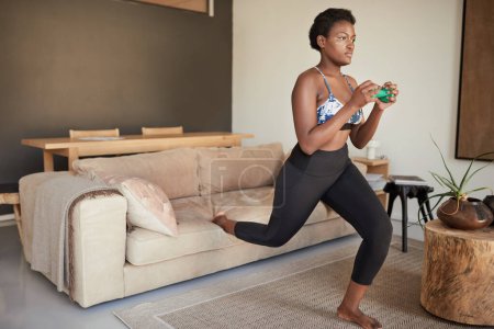 Foto de Saltando en el salón. una joven que hace ejercicio en casa - Imagen libre de derechos