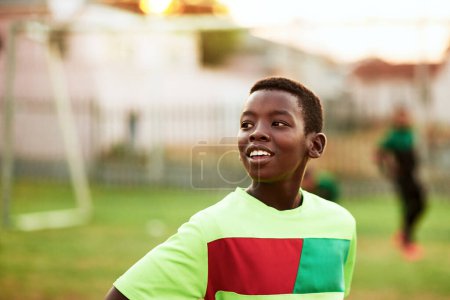 Foto de Practicar un deporte es una gran manera para que los niños se relajen. un niño jugando al fútbol en un campo de deportes - Imagen libre de derechos