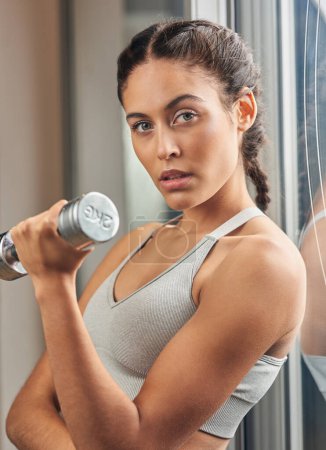 Photo for Toned arms are what Im after. Cropped portrait of an attractive young female athlete working out with a dumbbell in the gym - Royalty Free Image