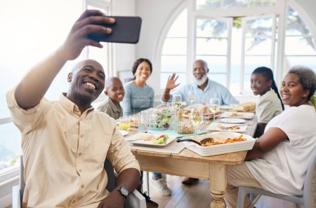 Téléchargez les photos : Les repas en famille permettent à la famille de se réunir. une famille prenant un selfie tout en déjeunant à la maison - en image libre de droit