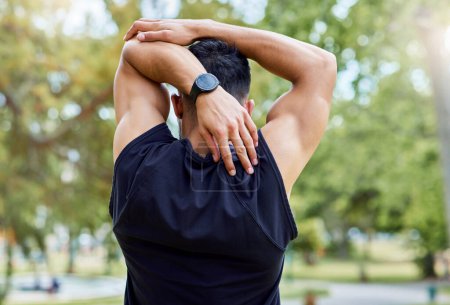 Photo for Your risk for injury increases if you dont stretch. Rearview shot of a sporty young man stretching his arms while exercising outdoors - Royalty Free Image