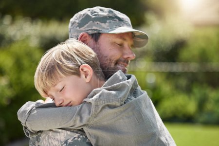 Photo for Family means no one gets left behind. a father returning from the army hugging his son outside - Royalty Free Image