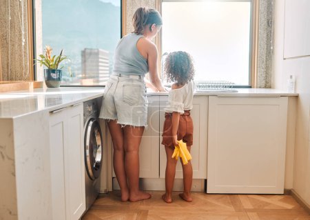 Téléchargez les photos : Petite fille aidant sa mère avec les tâches ménagères à la maison. Joyeux maman et fille laver la vaisselle dans la cuisine ensemble. Apprendre à être responsable en faisant des tâches. - en image libre de droit