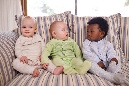 Foto de Amigos desde una edad temprana. tres bebés adorables sentados en un sofá - Imagen libre de derechos