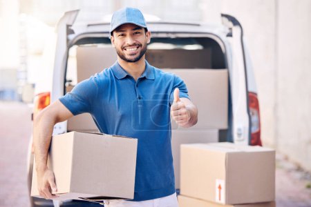 Photo for To give real service you must add something. Portrait of a young delivery man showing thumbs up while holding a box - Royalty Free Image