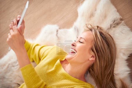 Foto de Pero primero tomémonos una selfie. Una mujer yong sonriendo feliz mientras toma un autorretrato en su tableta digital - Imagen libre de derechos