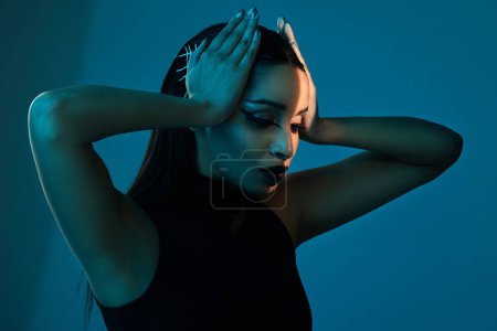 Photo for Style dilemma. Conceptual shot of a stylish young woman posing in studio against a blue background - Royalty Free Image