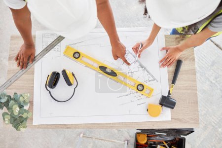 Photo for This isnt going to fit. High angle shot of two unrecognisable contractors standing inside together and looking at building plans - Royalty Free Image