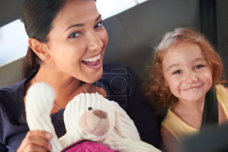 Photo for Family means nobody gets left behind or forgotten. A beautiful mother and daughter keep each other entertained while travelling at the back of a car - Royalty Free Image