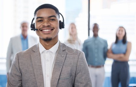 Photo for Customer support superheroes at your service. Portrait of a young businessman using a headset in a modern office with his team in the background - Royalty Free Image