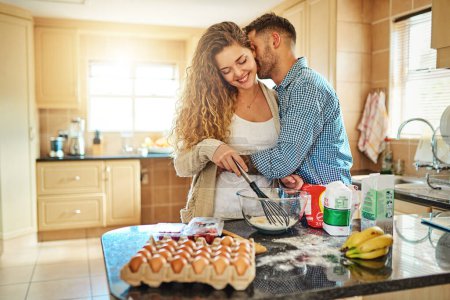 Photo for Baking is love made visible. a young couple mixing ingredients in their kitchen - Royalty Free Image