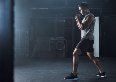 Photo for Keep up the pace, keep up the progress. a young man practicing his kickboxing routine at a gym - Royalty Free Image