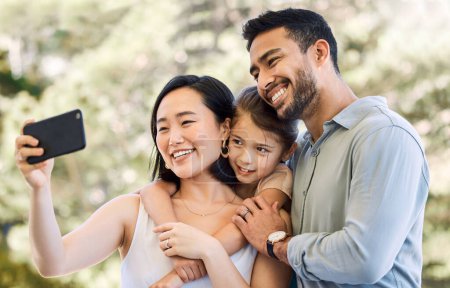 Téléchargez les photos : Mes amours, la lumière de ma vie. une jeune famille heureuse prenant des selfies dans un jardin - en image libre de droit